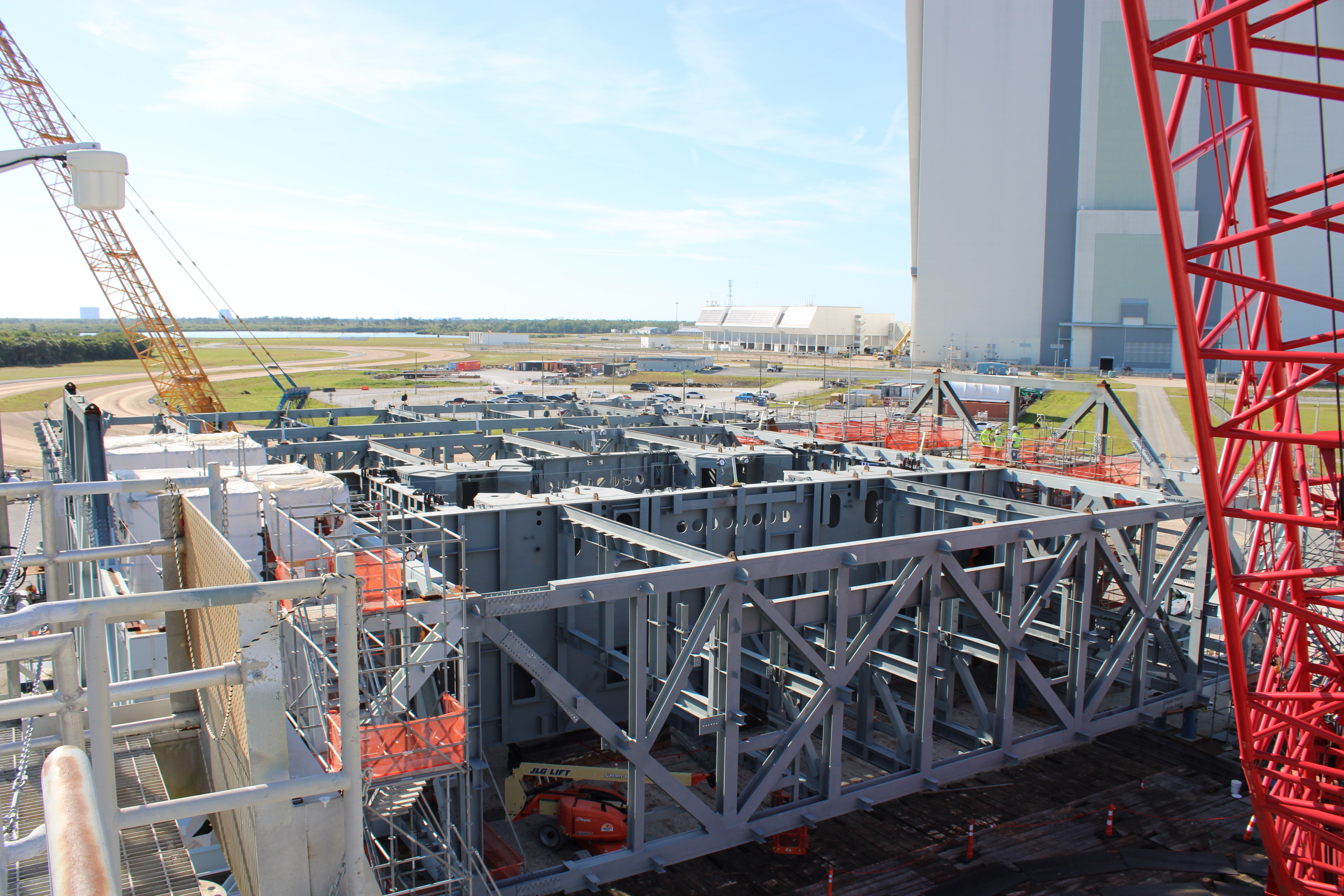 View of progress on the Mobile Launcher 2 base at Kennedy Space Center with the VAB in the background. 