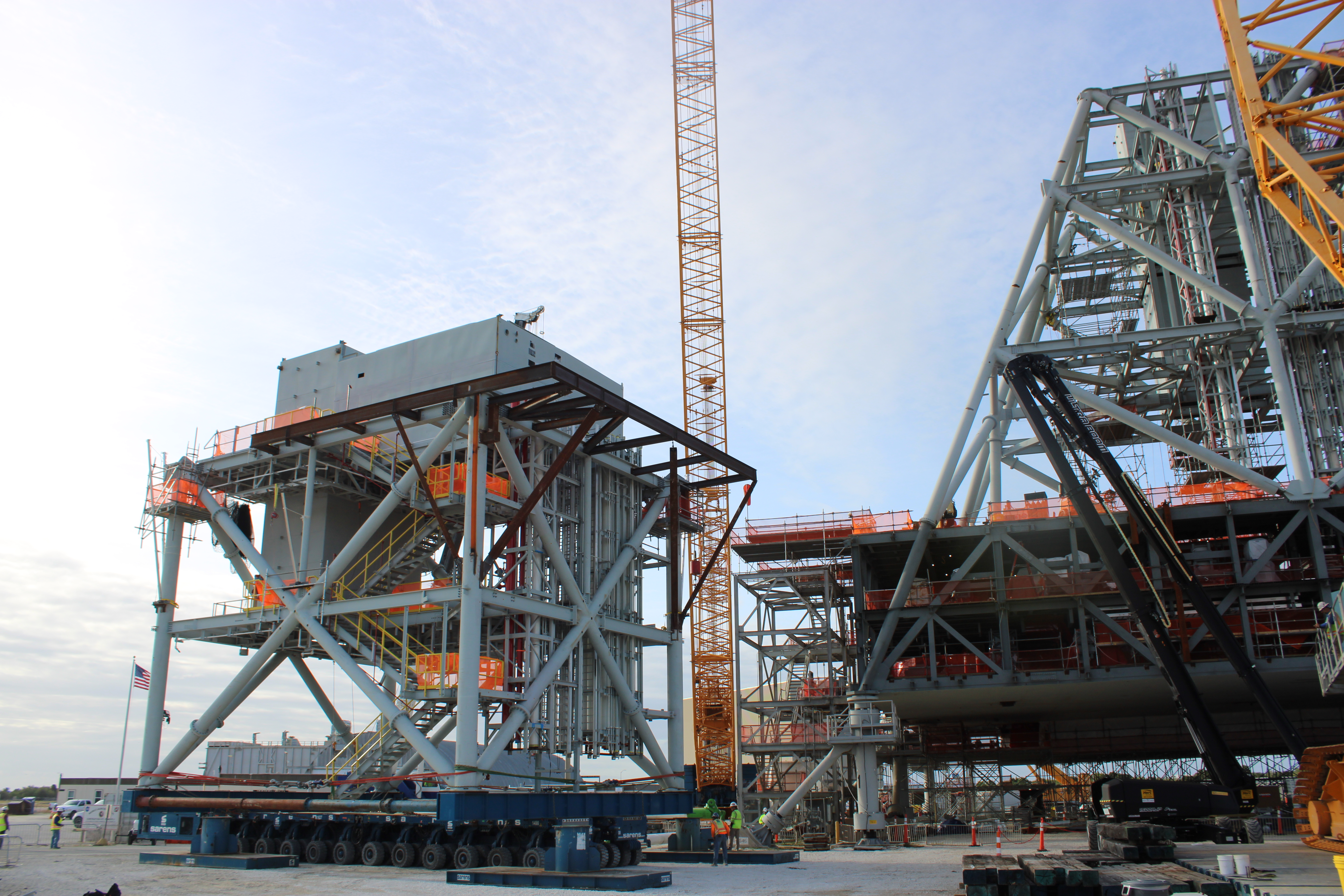 Mod 4 arrives to the Mobile Launcher 2 Parksite after a 6-mile journey across Kennedy Space Center, with the CC8800 Demag crane and ML2 base in view.