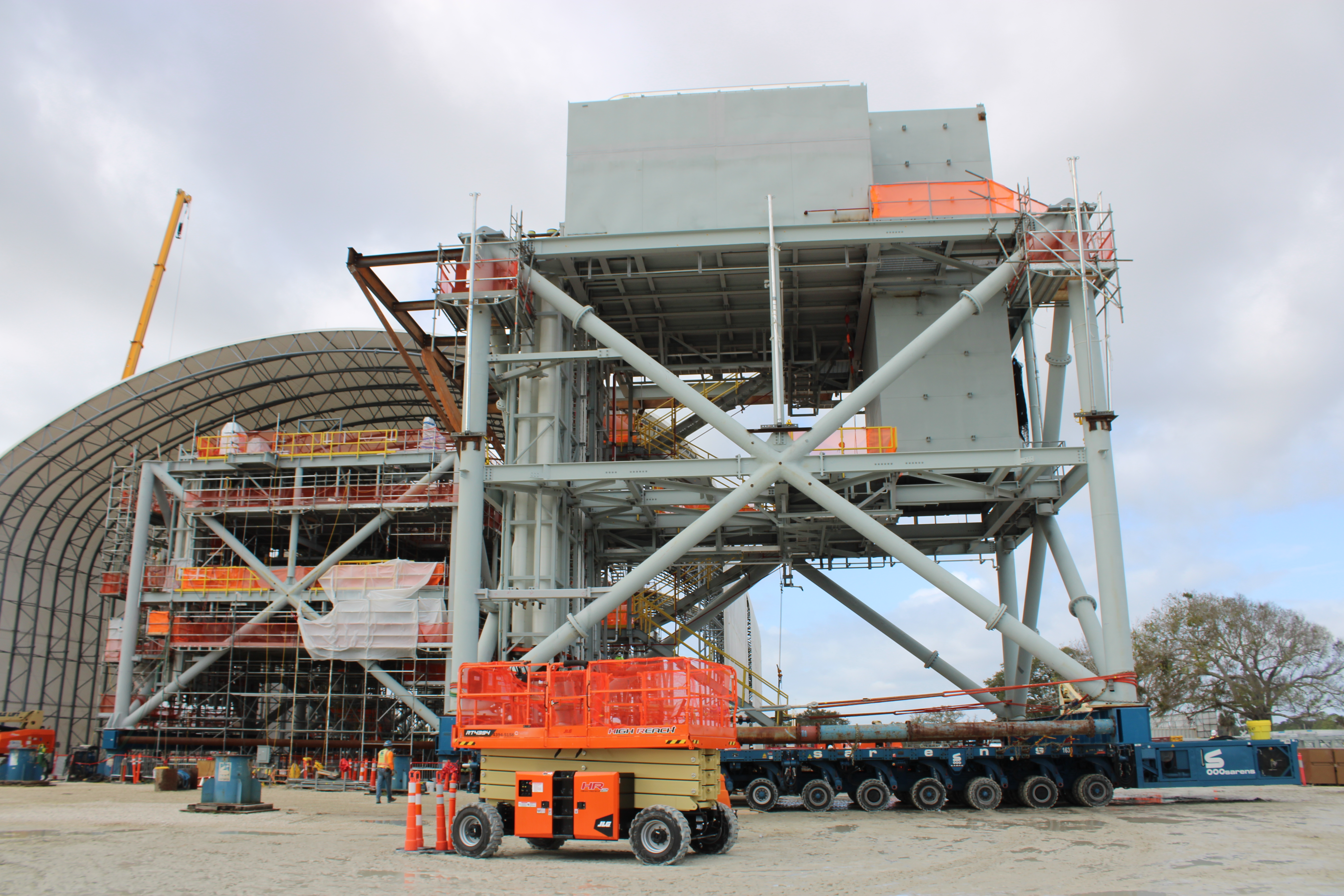 Two SPMTs drive Mod 4 away from its staging location at the ML2 Mod Yard as the module is driven to the Parksite.