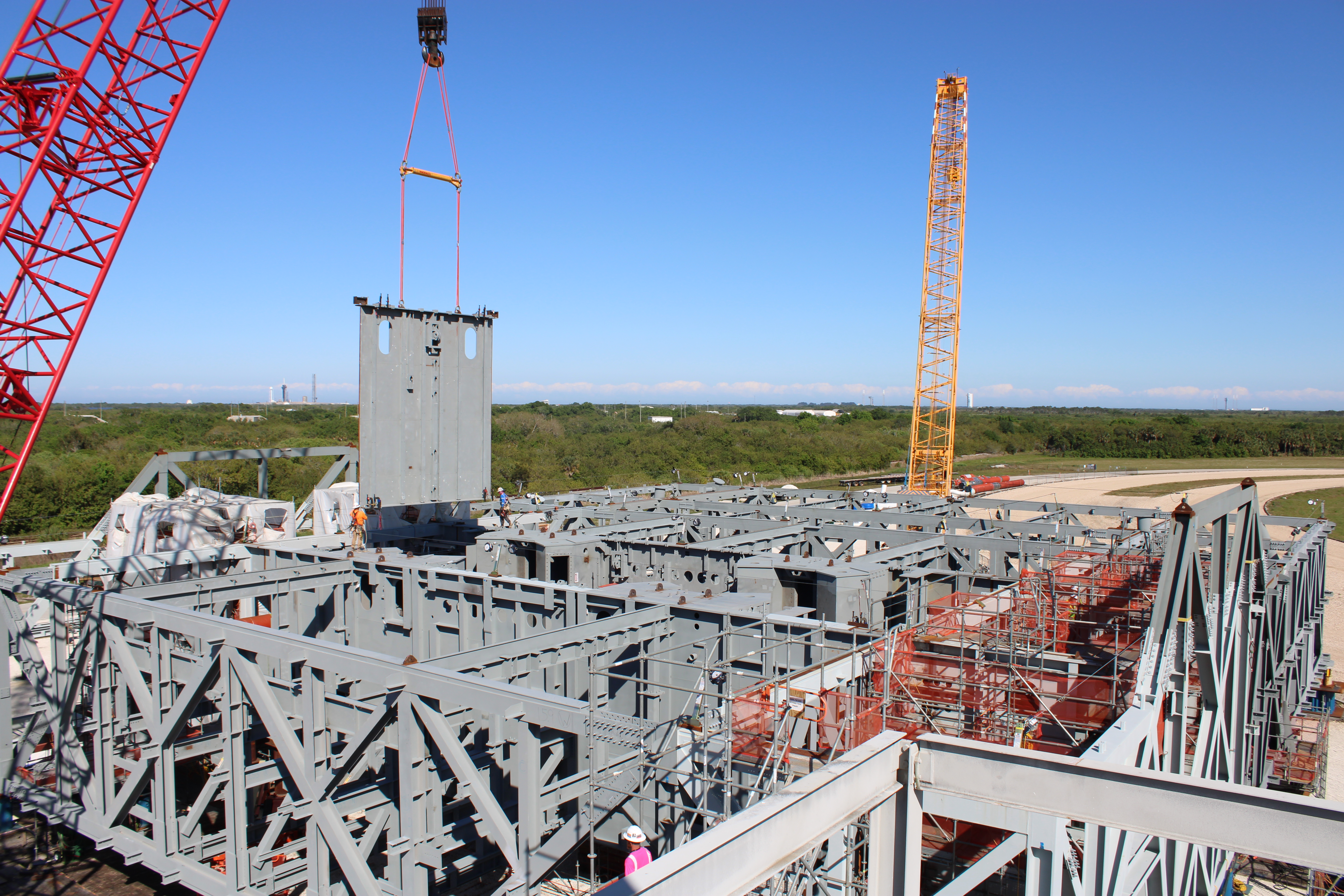 The lift of a steel girder in progress on the mobile launcher 2 base at Kennedy Space Center.